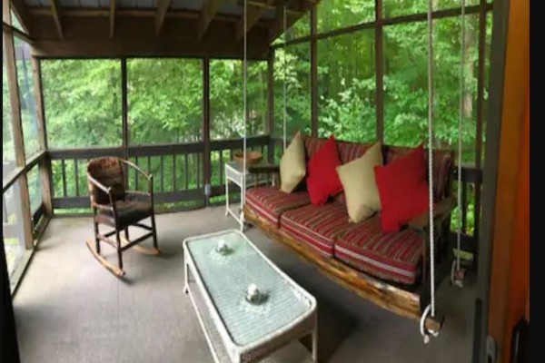 Covered screened porch nestled in the trees