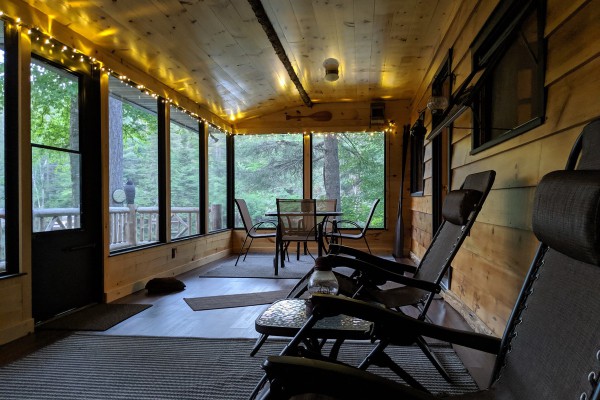 Large screened in porch area with furniture 