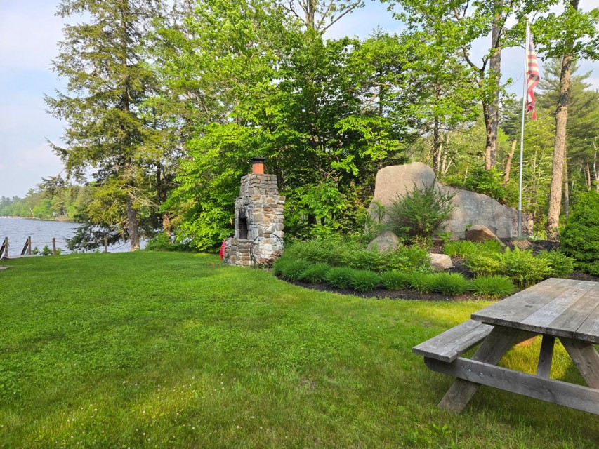 Outdoor fireplace + large grass area to play by lake