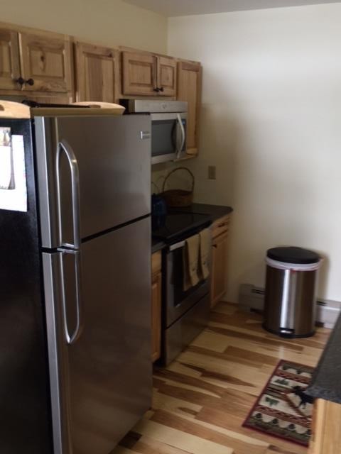 Kitchen with refrigerator, oven and microwave