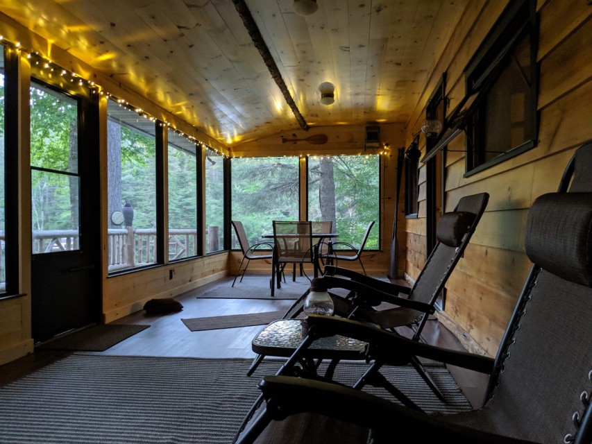 Large screened in porch area with furniture 