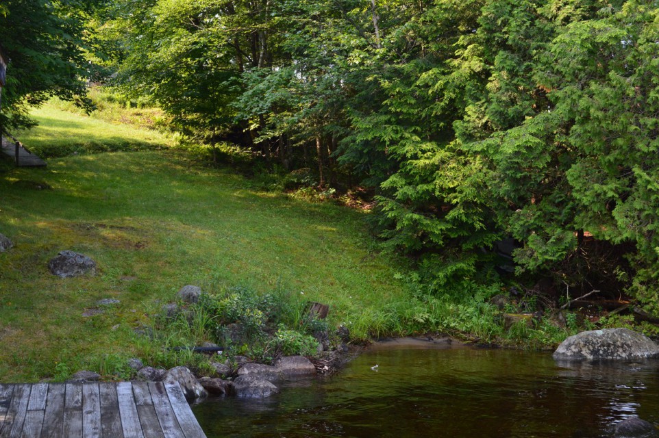 The beach, dock and boathouse on left. Note: steep hill