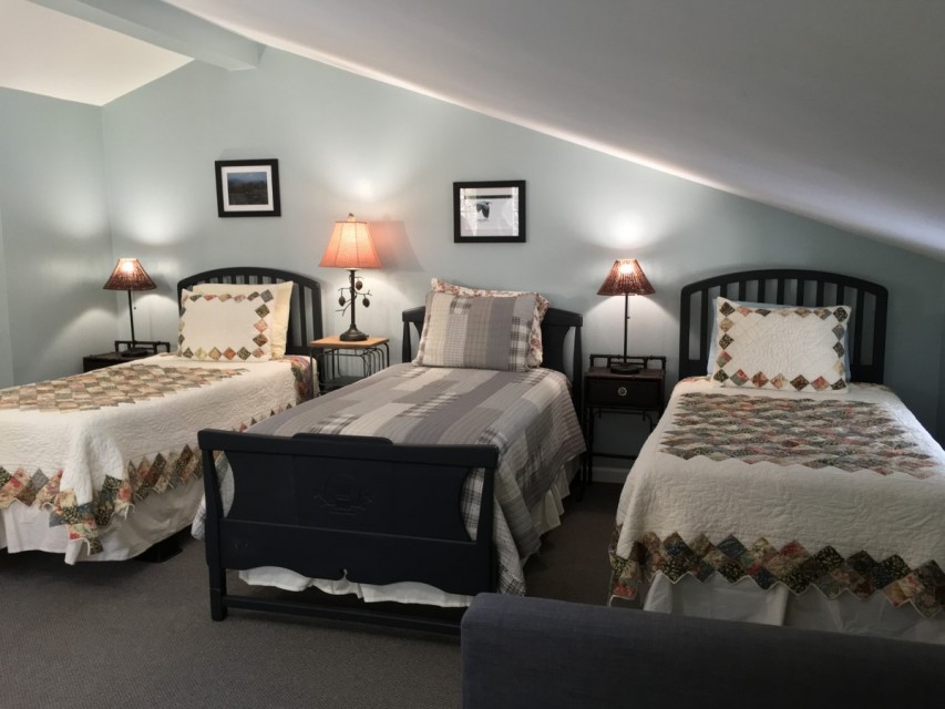 Upstairs bedroom with three twin beds and half-bath