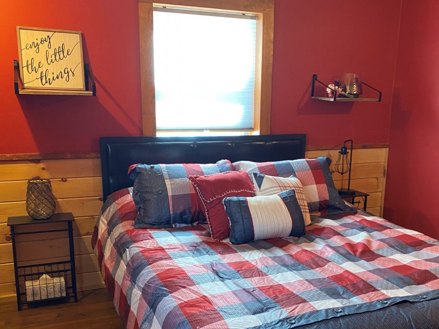 Main level red bedroom with queen bed / closet