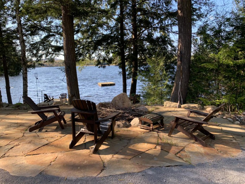 Outdoor fire pit with view of dock and lake.