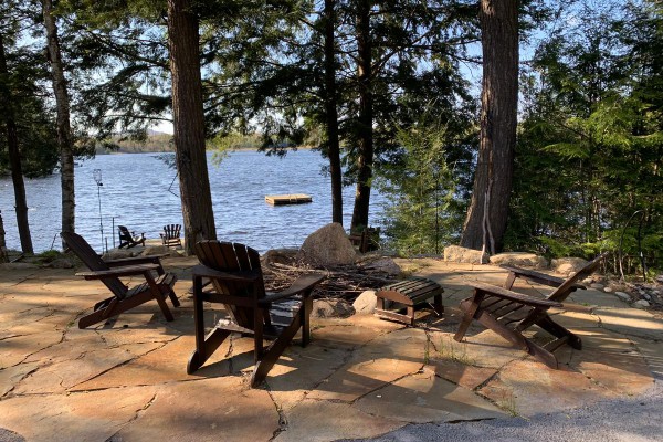 Outdoor fire pit with view of dock and lake.