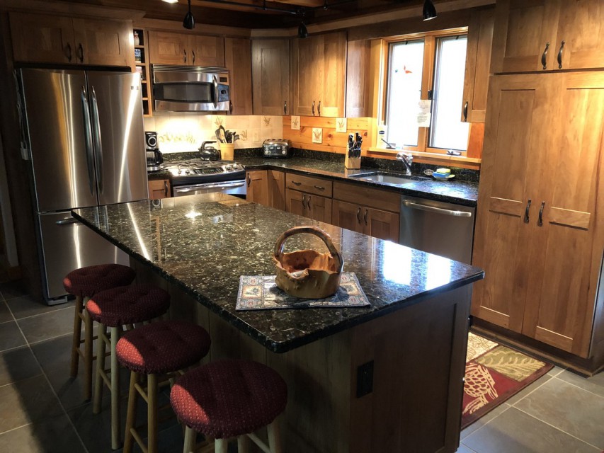 Kitchen with stainless appliances, large granite island