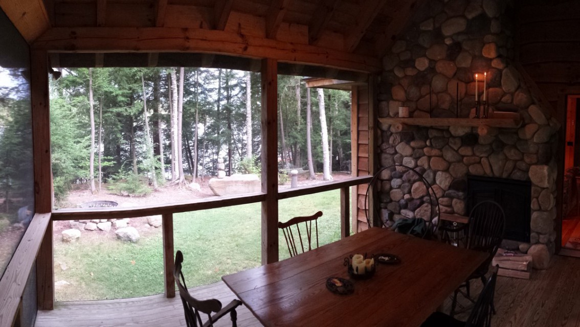 Screened porch dining, lake through the trees