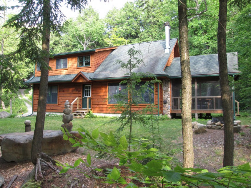 Lakeside of camp with screened porch right, fire pit