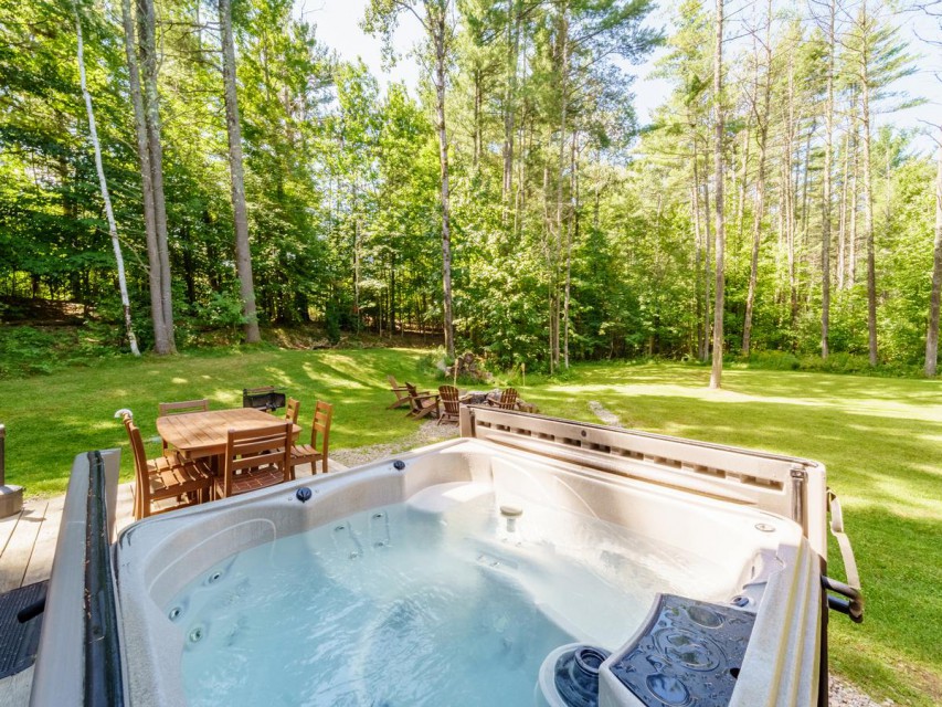 The hot tub has a lovely view to the fire pit and yard.