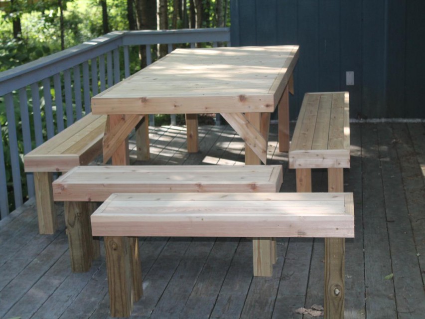 Large picnic table at one end of deck for house